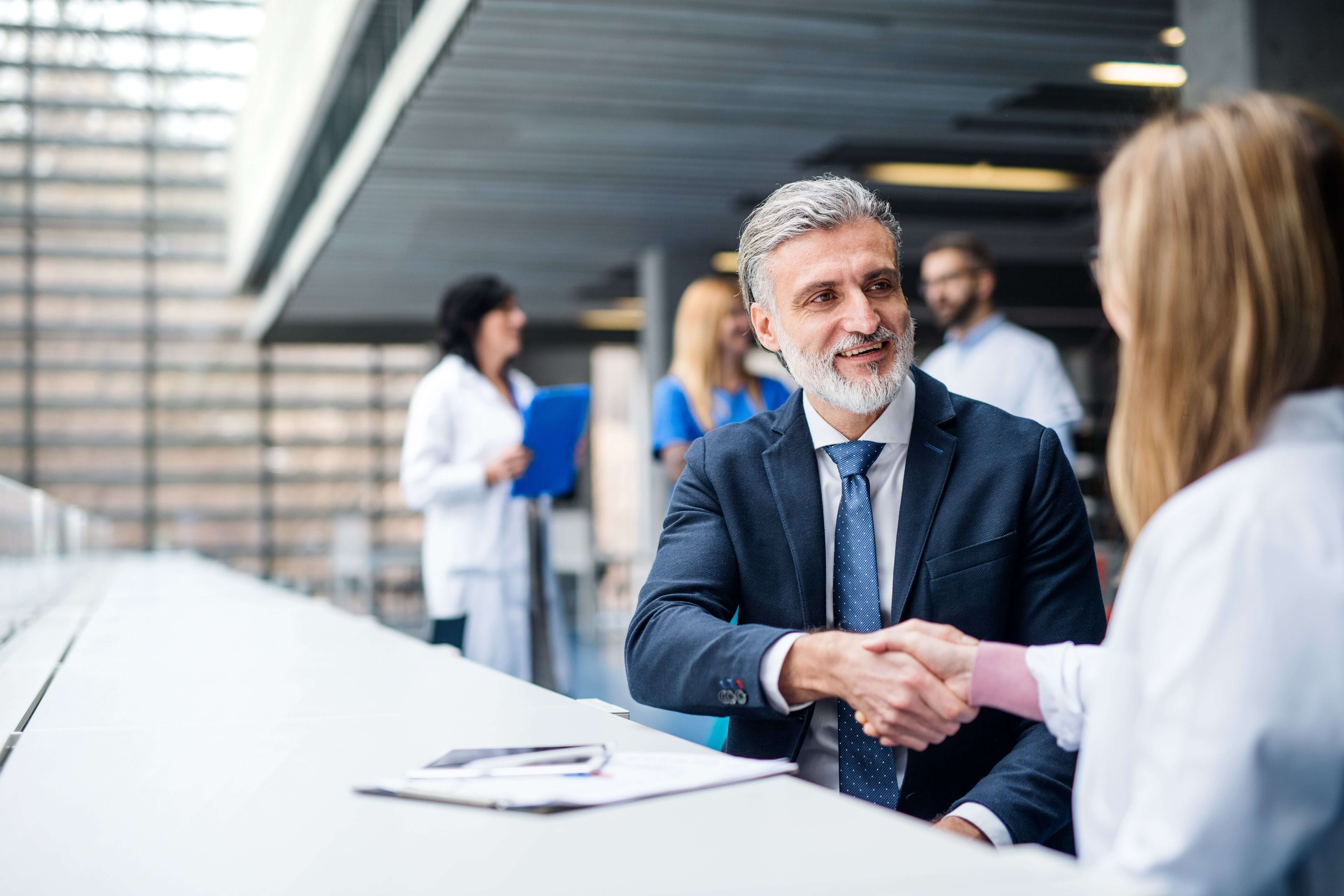 A man and a woman are pictured shaking hands.
